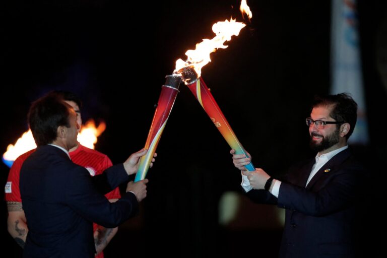 El presidente de Chile, Gabriel Boric (derecha), enciende una de las antorchas que recorrerá el país, sostenida por el Ministro de Deportes de Chile, Jaime Pizarro, durante una ceremonia de recepción de la antorcha de los Juegos Panamericanos en la Terraza Caupolicán, Cerro Santa Lucía, en Santiago, el 30 de septiembre de 2023. . (Foto de JAVIER TORRES/AFP vía Getty Images)