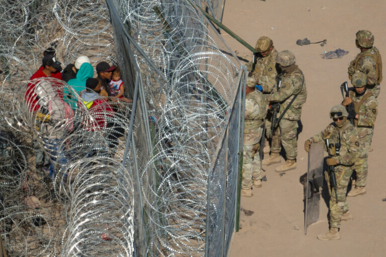 Miembros de la Guardia Nacional del Ejército disuaden a los migrantes que intentan cruzar a los EE.UU. más allá de alambre de púas en El Paso, Texas, EE.UU., 22 de marzo 2024. (REUTERS/Adrees Latif)